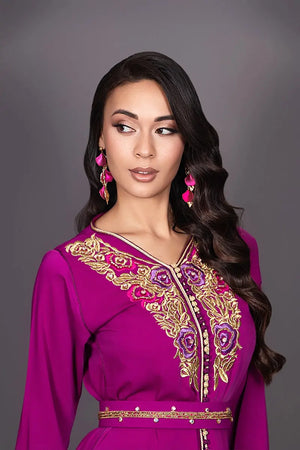 Gros plan sur les finitions sfifa et aâqads fuchsia et doré du caftan marocain