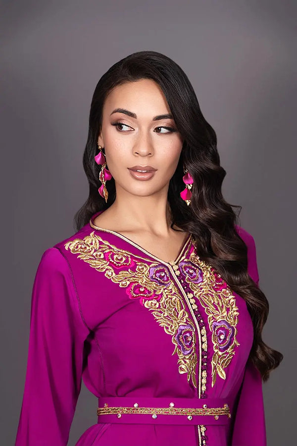 Gros plan sur les finitions sfifa et aâqads fuchsia et doré du caftan marocain