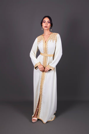 Caftan blanc ivoire luxe avec broderies dorées et ceinture assortie, tenue cérémonies et mariages.