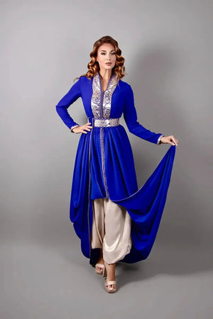 Koningsblauwe caftan gedragen met wijde satijnen broek, die de vloeiende snit en verfijnde afwerking benadrukt.