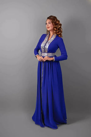Driekwartaanzicht van de koningsblauwe caftan die de vloeiende silhouet en de verfijnde snit benadrukt.
