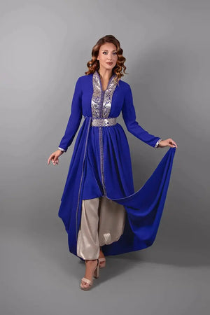 Detail van de beweging en de val van de koningsblauwe caftan met traditionele Marokkaanse borduursels.