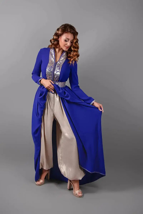 Vrouw draagt een elegante koningsblauwe caftan met geborduurde ceintuur en zilveren details.