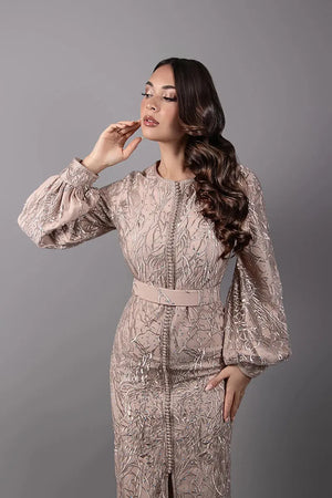 Caftan Essyra beige nude avec broderies scintillantes et manches bouffantes, détail du buste et de la ceinture assortie.