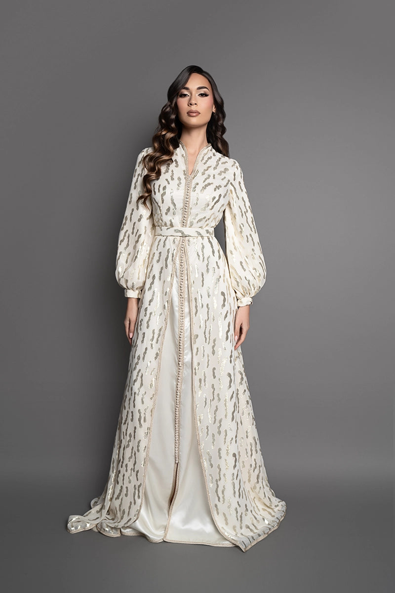 Caftan marocain ivoire Wiheme avec motifs dorés scintillant, manches bouffantes et ceinture assortie, tenue élégante pour mariage et cérémonie.