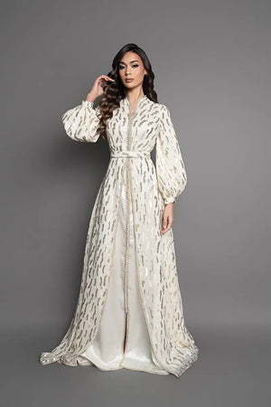 Elfenbeinfarbener marokkanischer Kaftan mit goldenen Mustern, langem, elegantem Schnitt und passendem Gürtel für eine traditionelle Hochzeit.