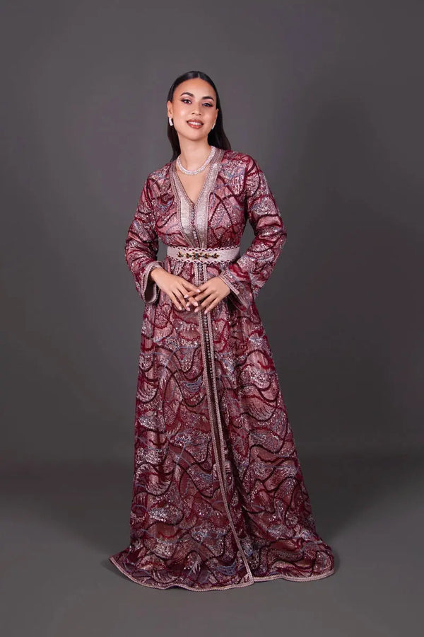 Takchita Aurelia in Bordeauxrot und Puderrosa aus mit Pailletten bestickter Spitze, mit einem mit Steinen verzierten Gürtel und laméfarbenem Futter – ein elegantes marokkanisches Outfit für Hochzeiten.